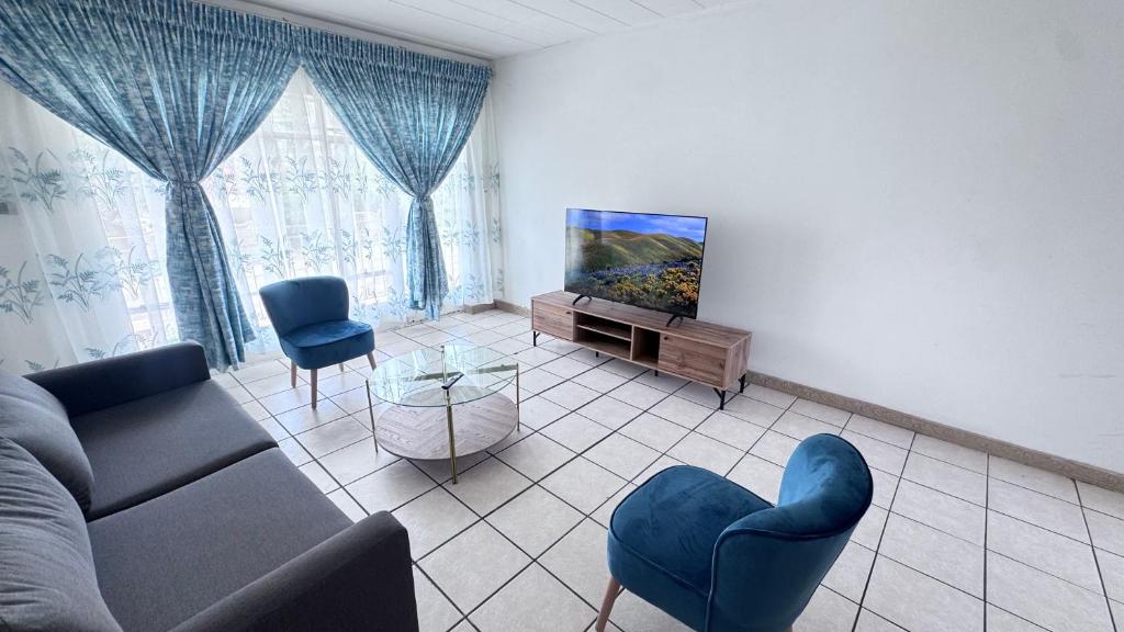 een woonkamer met een bank en een flatscreen-tv bij Croydon Vista Luxe in Kempton Park