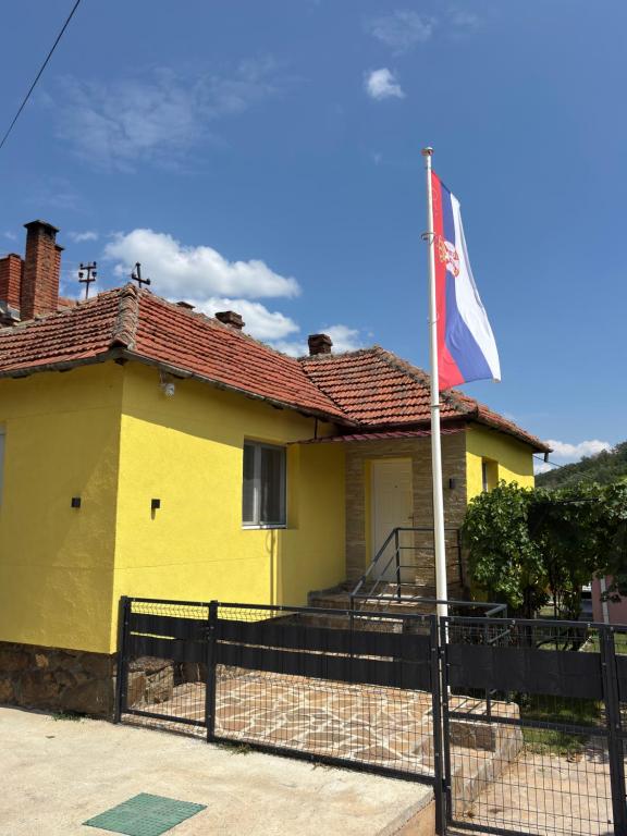a yellow house with a flag in front of it at Vilasukovo in Sukovo