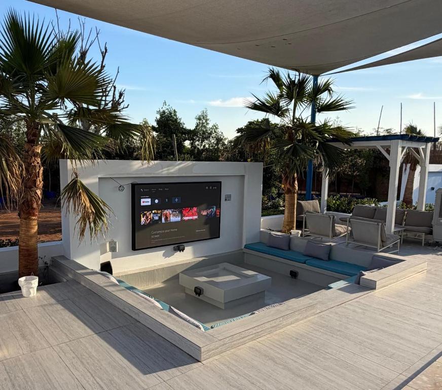 een woonkamer met een flatscreen-tv op een terras bij Santorini check in in Ras al Khaimah