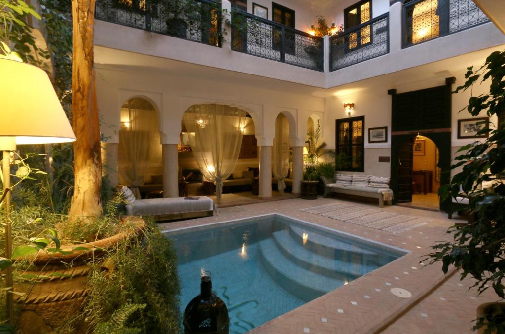 a house with a swimming pool in a yard at Riad Anjar in Marrakesh