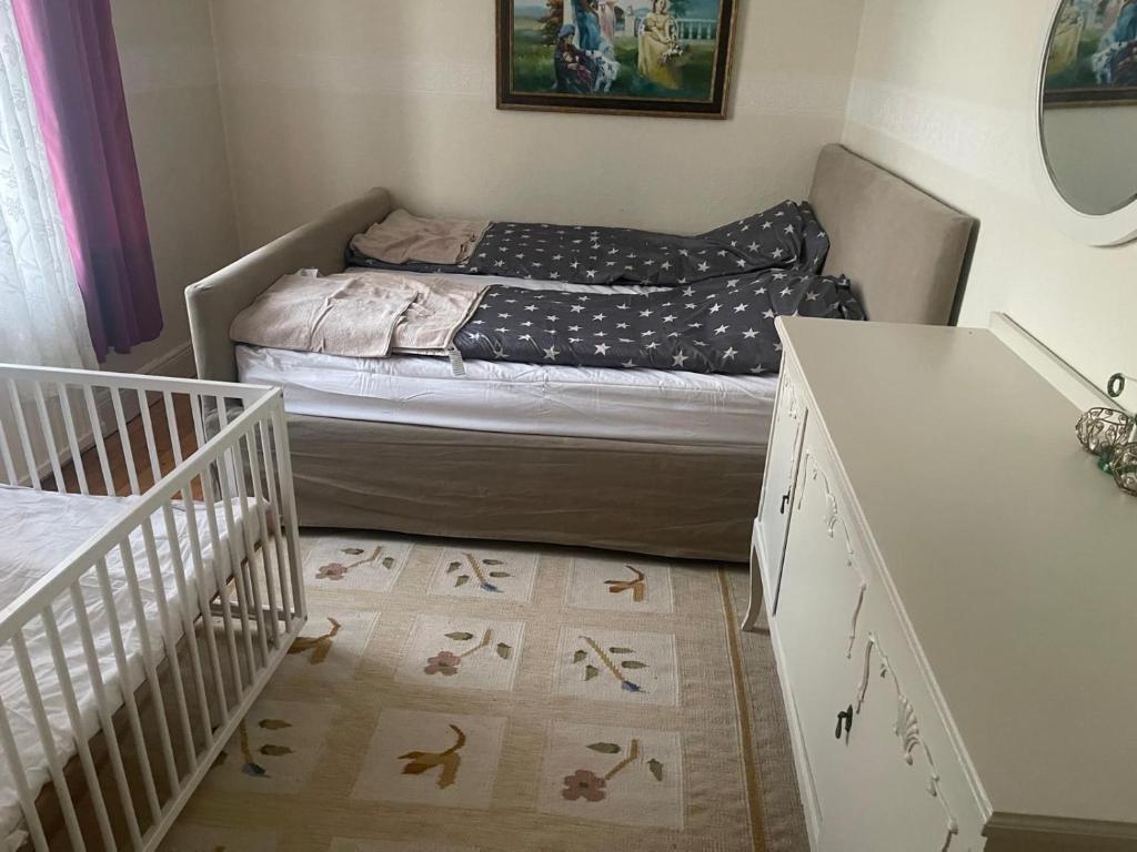 ein kleines Schlafzimmer mit einem Bett und einem Kinderbett in der Unterkunft Spacious and charming apartment in central Storvik in Storvik