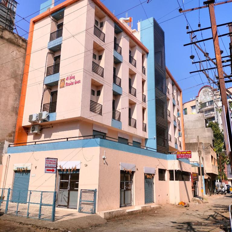 a building on a street corner in a city at Hotel Madhav Shankar in Rajkot