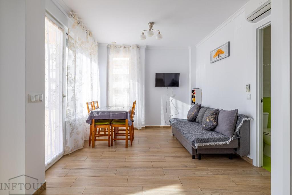 een woonkamer met een bank en een tafel bij Inftour President 2 Apartamento in Calpe