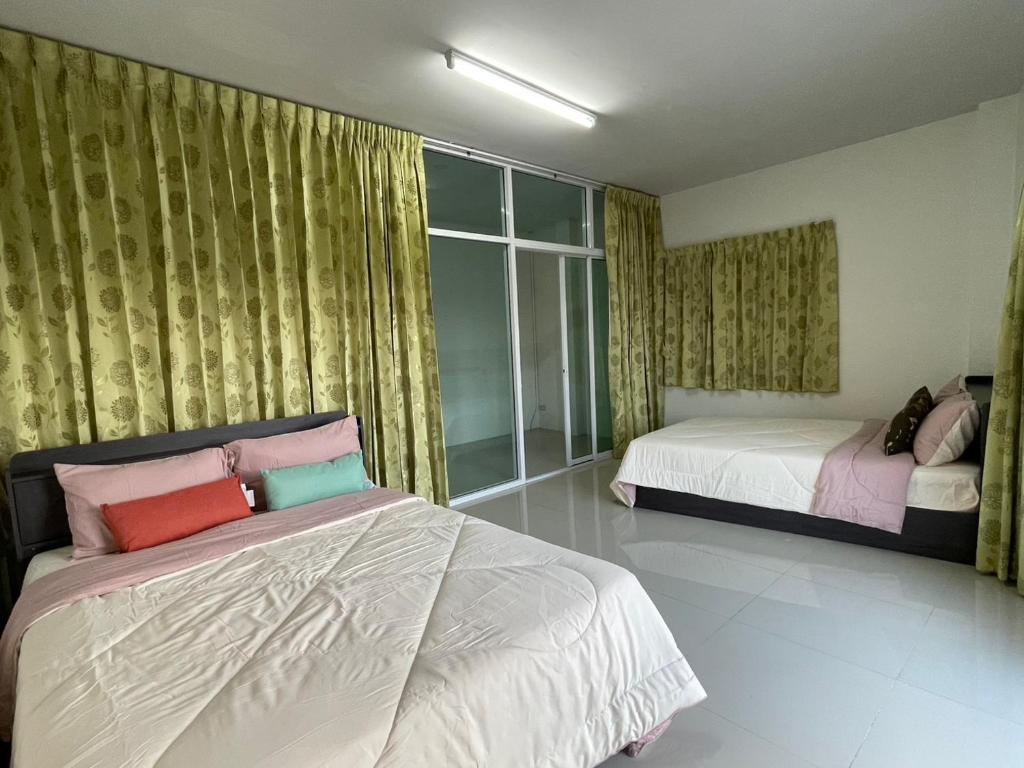 ein Schlafzimmer mit zwei Betten und einem Fenster in der Unterkunft ท่าบูรพาวิลล่า ที่พักพร้อมสระน้ำ ทั้งหลัง in Ban Hua Khao Sammuk