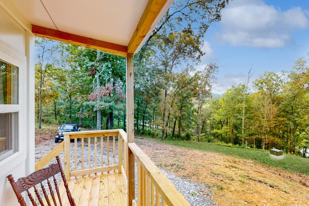 een veranda met een bank en uitzicht op een tuin bij Charming Tiny Home Studio Sleeps 2 - Grill - Porch in Acuff