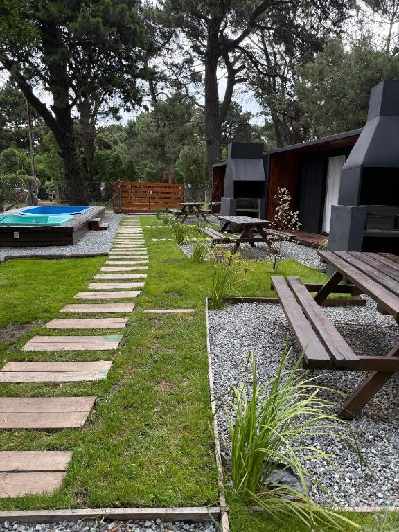a backyard with a picnic table and a bench at La Posada Bungalows in Necochea