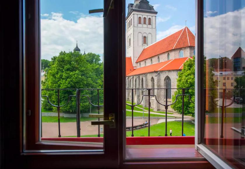 uma janela aberta com vista para uma igreja em Tallinn City Apartments Residence em Talin