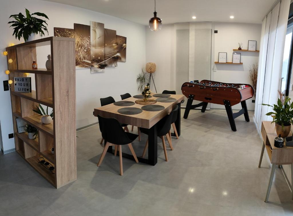una sala da pranzo con tavolo e tavolo da biliardo di Alsace Elégance Suite a Wittelsheim