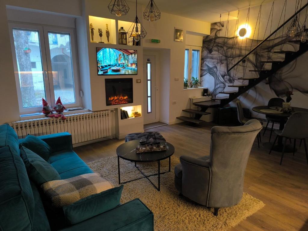 un salon avec un canapé bleu et un escalier dans l'établissement Marigold Centar NS, à Novi Sad