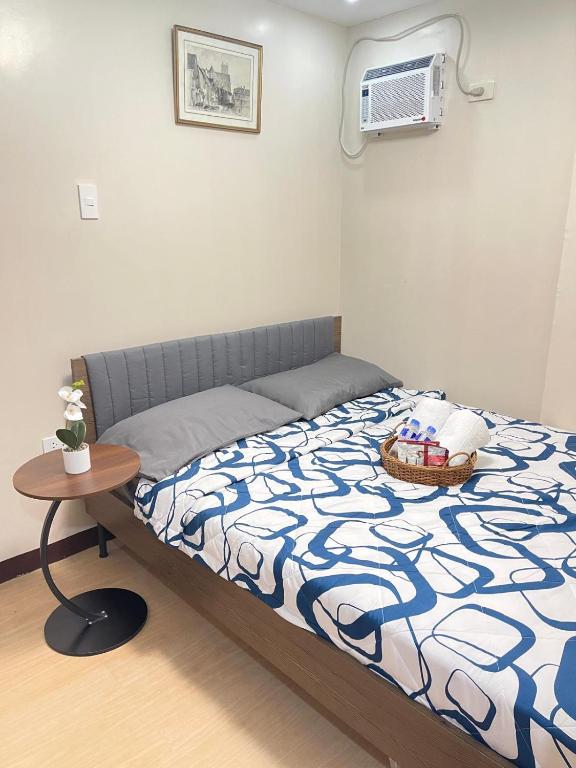 a bedroom with a bed with a table and a air conditioner at Potot Haven Dorm and Transient in Libmanan