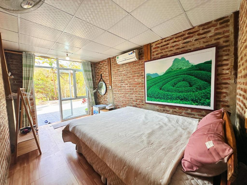 een slaapkamer met een bed en een groot schilderij aan de muur bij Nà Bó Homestay in Mộc Châu