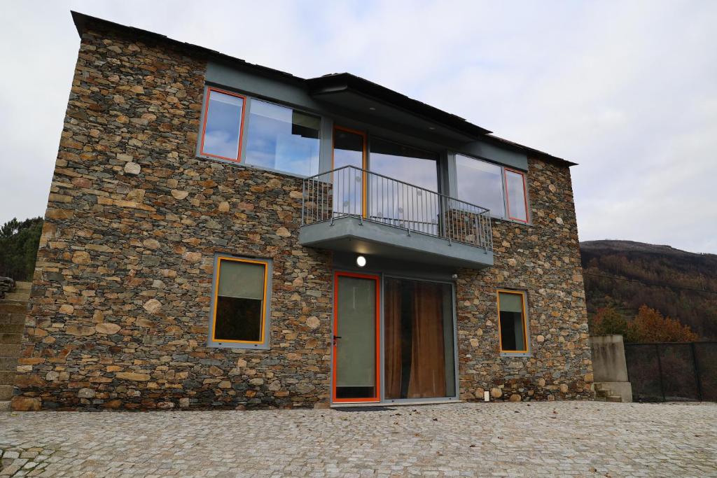 een gebouw met een balkon aan de zijkant bij MedronHouse - Casa de Campo in Vasco Esteves de Baixo