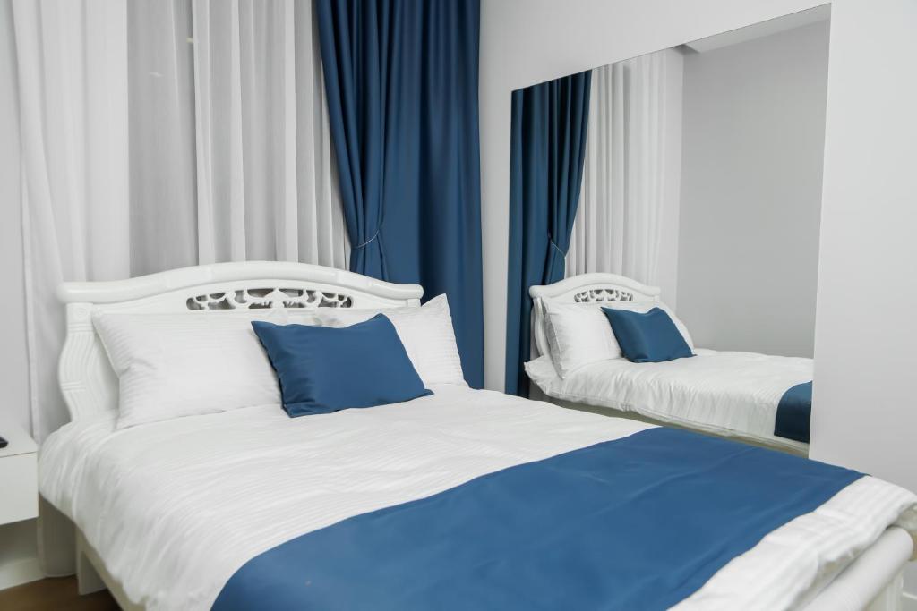 deux lits dans une chambre avec du bleu et du blanc dans l'établissement Barca Hotel, à Erevan