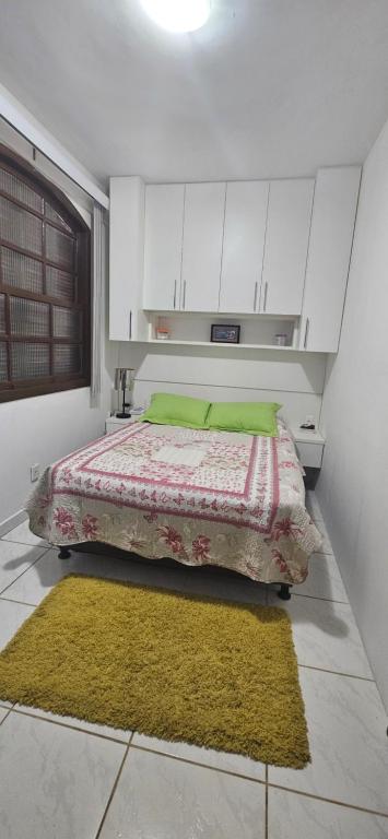 a bedroom with a bed and a yellow rug at Flat Saigon Barra de Maricá Pé na Areia Wi-Fi in Maricá