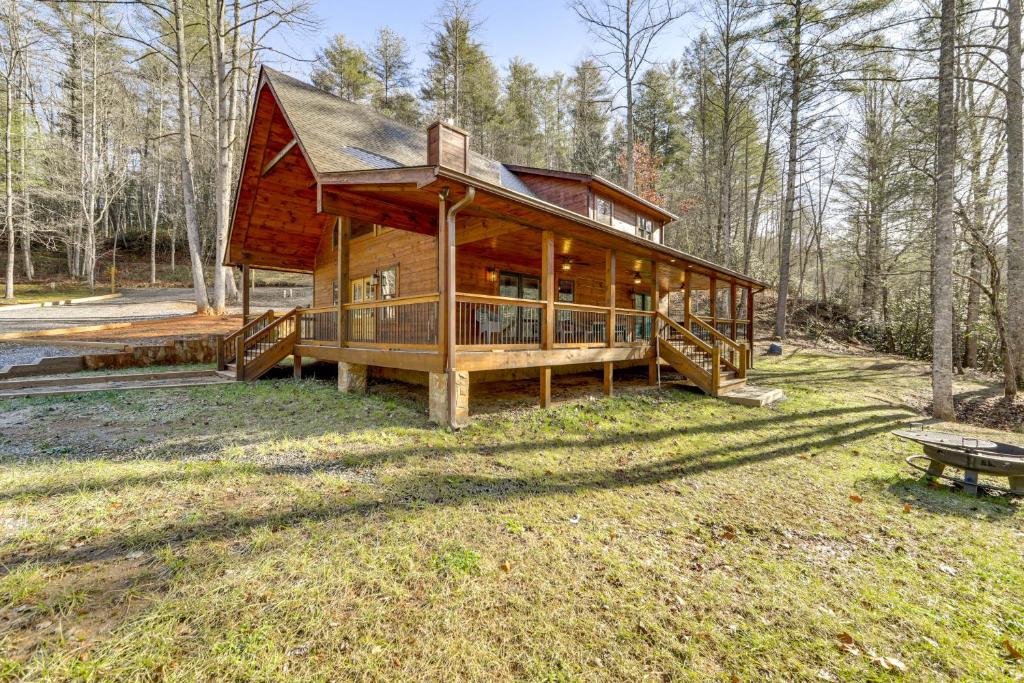 una grande casa in legno in mezzo a una foresta di Riverfront Cabin with Mtn Views in Robbinsville a Junction
