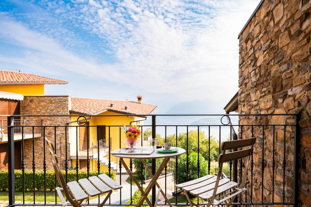 un patio con tavolo e sedie su un balcone di Italian Vacation Homes Unit2B Iseo Lake a Tavernola Bergamasca