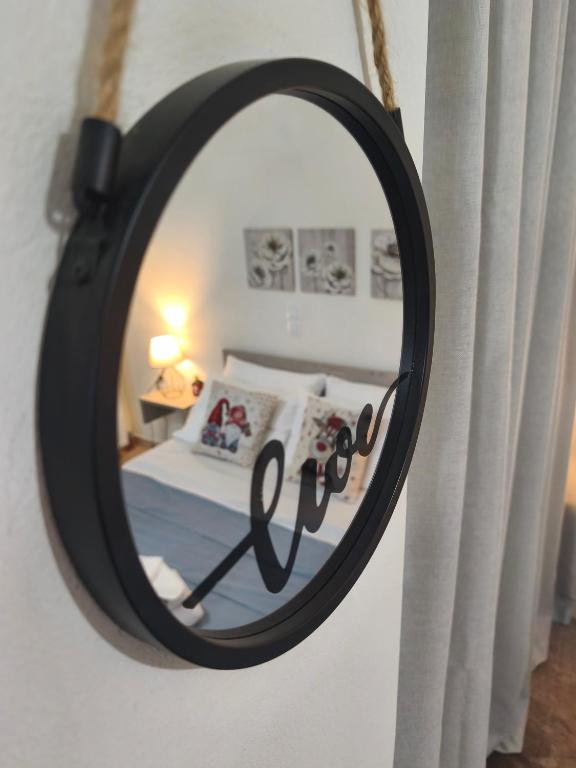 a mirror on a wall with a bed in a bedroom at Alkyona apartments in Kalavrita