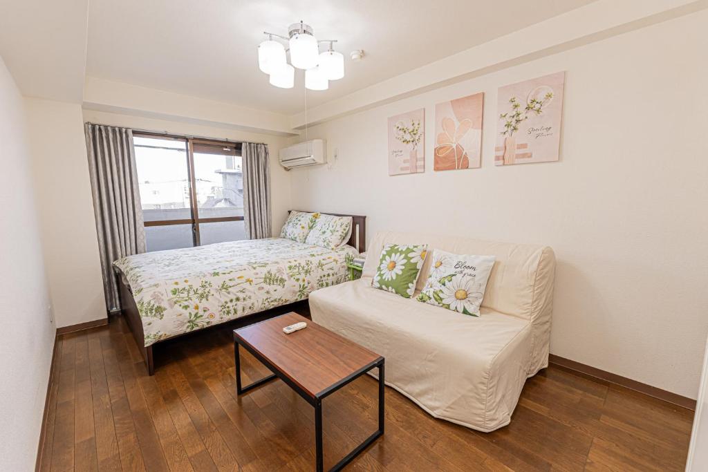 ein kleines Wohnzimmer mit einer Couch und einem Tisch in der Unterkunft sakura 405 in Tokio