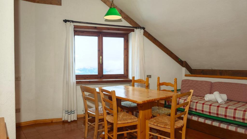 une salle à manger avec une table et des chaises en bois dans l'établissement Hostdomus- Abeti Apartments, à Sestrières