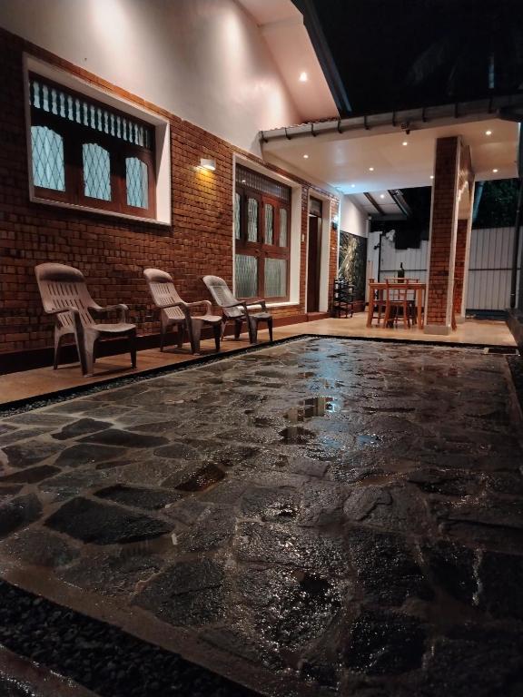 an empty lobby with chairs and a stone floor at Villa Green Garden in Hikkaduwa