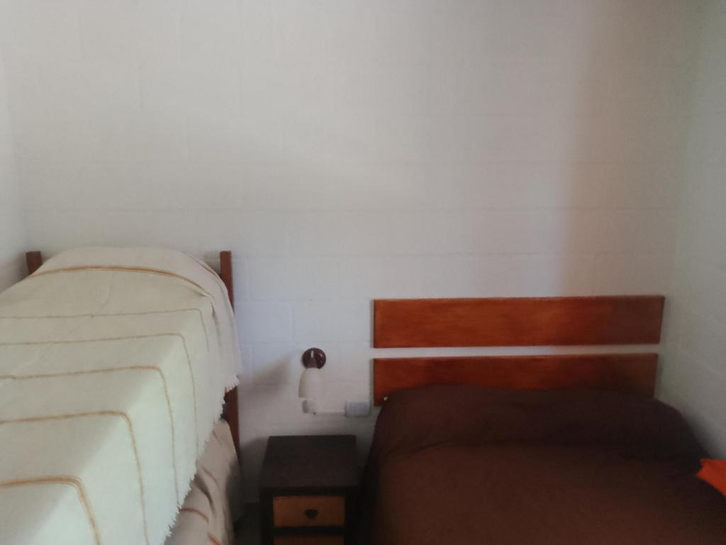 ein kleines Schlafzimmer mit einem Bett und einer Couch in der Unterkunft Depto Calamuchita Rumipal in Villa Rumipal