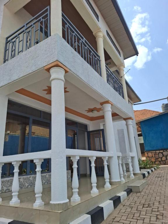 une maison avec des colonnes et un balcon dans l'établissement Kigali Great Home, à Kigali