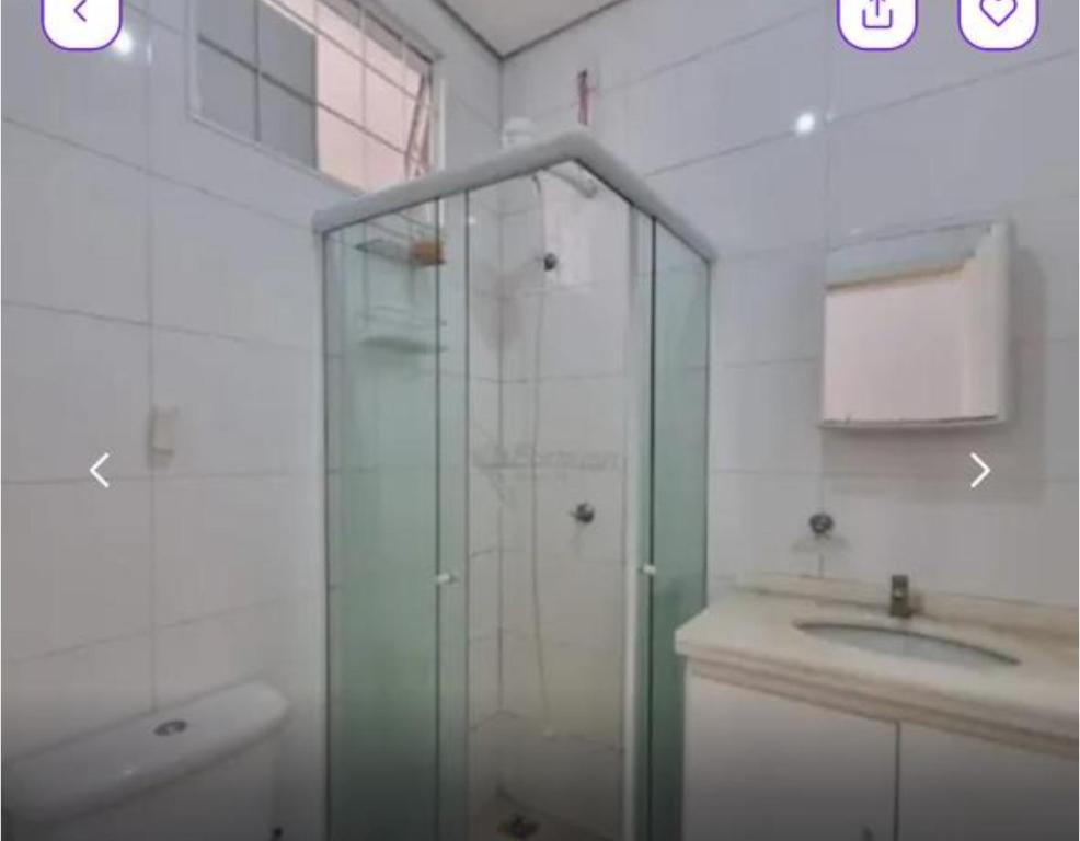 a bathroom with a glass shower and a sink at Kit Net Cidade Universitária in Limeira