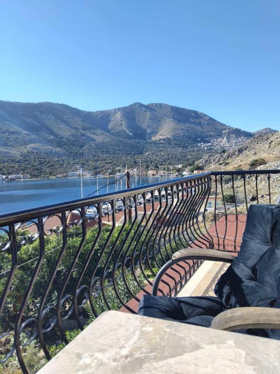 a bench sitting on a fence next to a body of water at Anasa house in Symi