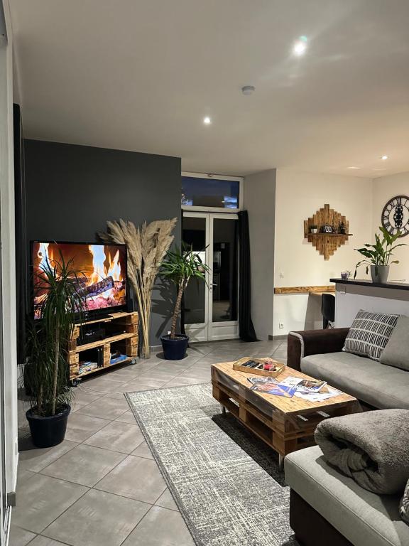 un salon avec un canapé et une télévision à écran plat dans l'établissement Chez Louis, à Saint-Flour