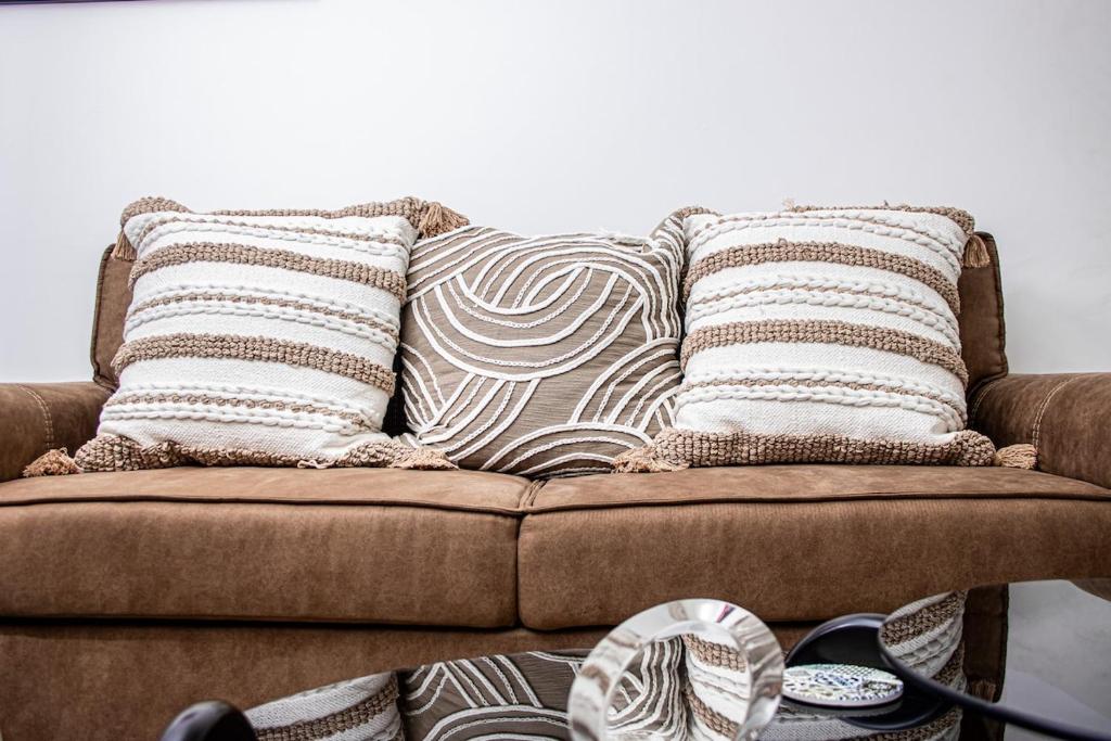 eine Couch mit zwei Kissen darüber in der Unterkunft Luxury 1 Bed Apartment in Sandton