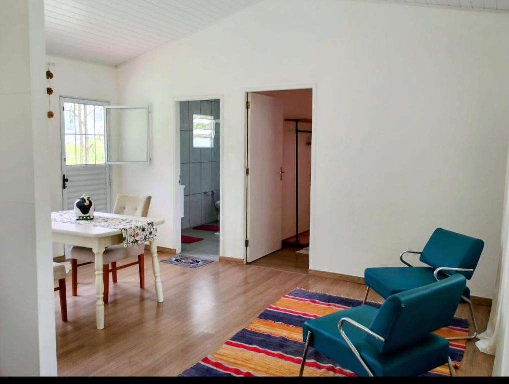 a living room with a table and chairs at Sitio JP in Pindamonhangaba