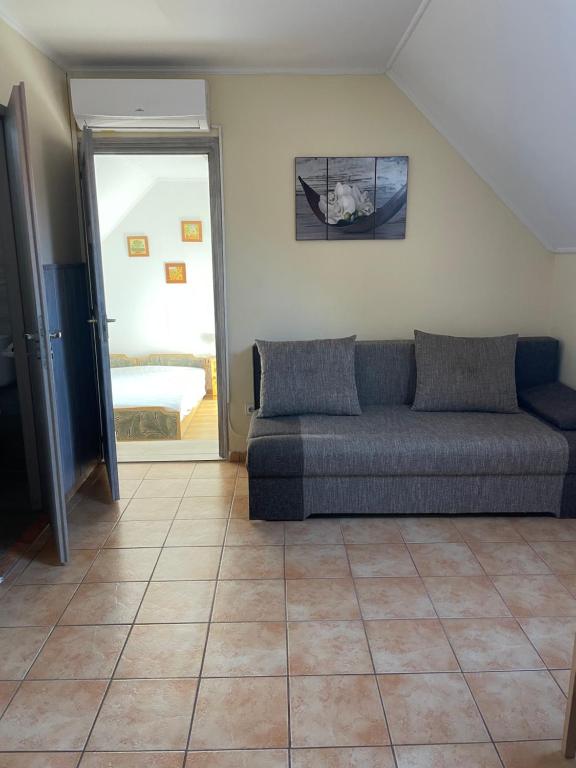 een woonkamer met een bank en een slaapkamer bij Leitner Ház in Balatongyörök