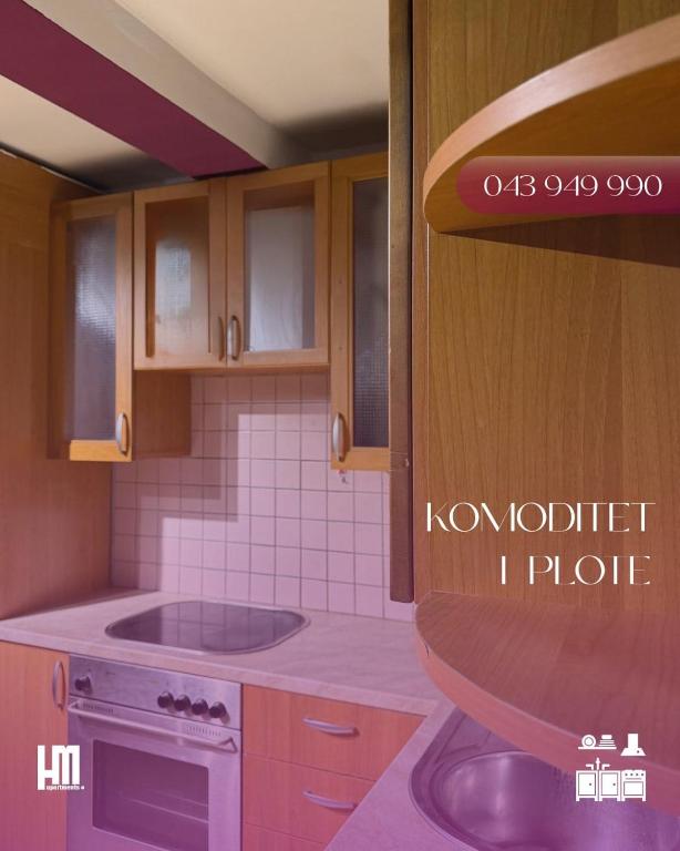 een keuken met een fornuis en een wastafel. bij HM Apartments in Pristina