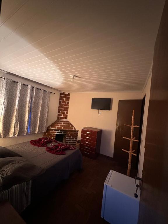 een kamer met een bed en een stenen open haard bij Pousada Taquaral in Bocaina de Minas