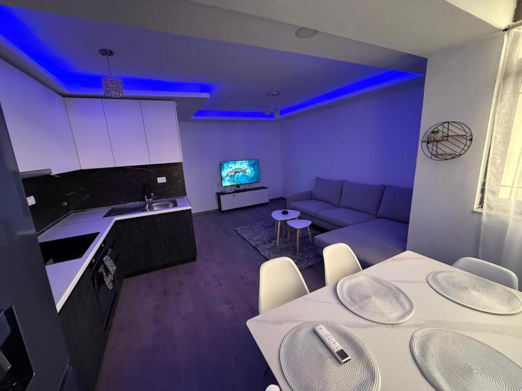 een woonkamer met witte tafels en een bank bij Shkodra Apartment AR in Shkodër