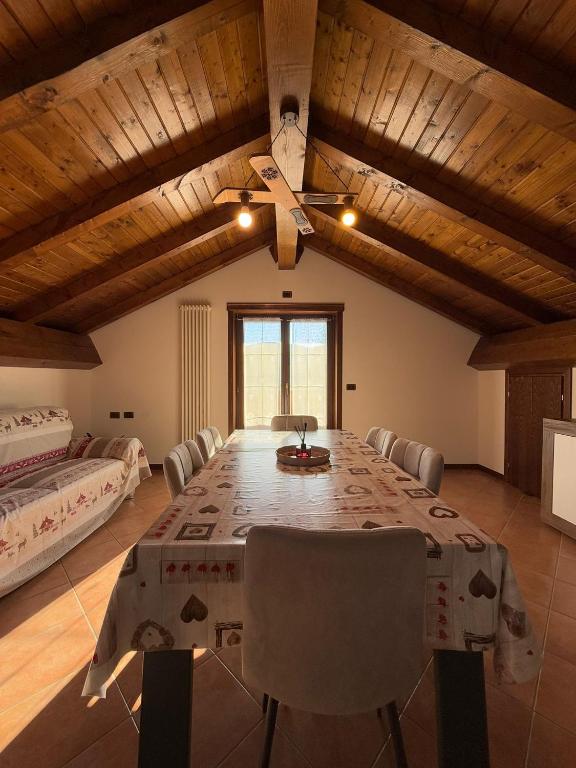 a dining room with a table and a ceiling fan at Al Cacciatore in Gallio