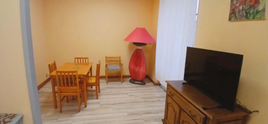 a living room with a table and a red lamp at Entre sel et vignes in Lons-le-Saunier