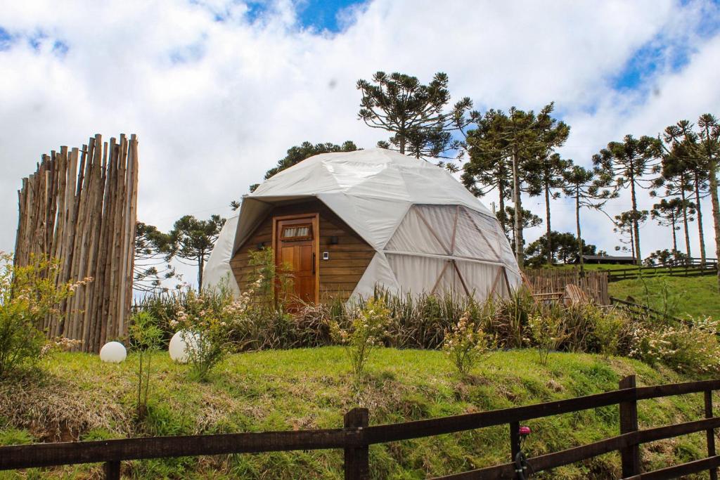 a yurt in a field next to a fence at Le Refuge Urubici in Urubici