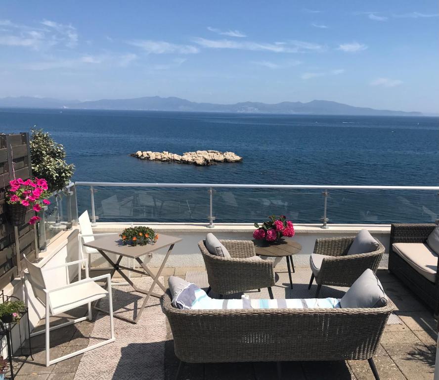 a balcony with chairs and tables and the ocean at C'est la vie! in L'Escala