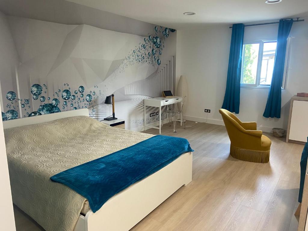 een slaapkamer met een bed, een bureau en een stoel bij Chambre atypique in Domène