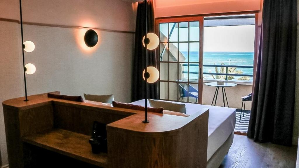 een slaapkamer met een bed en uitzicht op de oceaan bij JovA Hotel Boutique in El Campello
