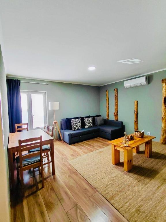 een woonkamer met een blauwe bank en een tafel bij Tree House II in Setúbal