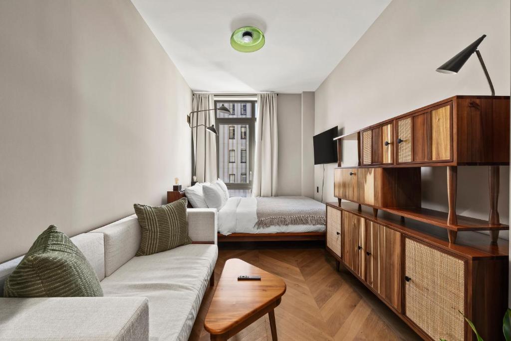un soggiorno con un divano e un letto di Freeman 602 by Rove - Condo with Shared Amenities a New York