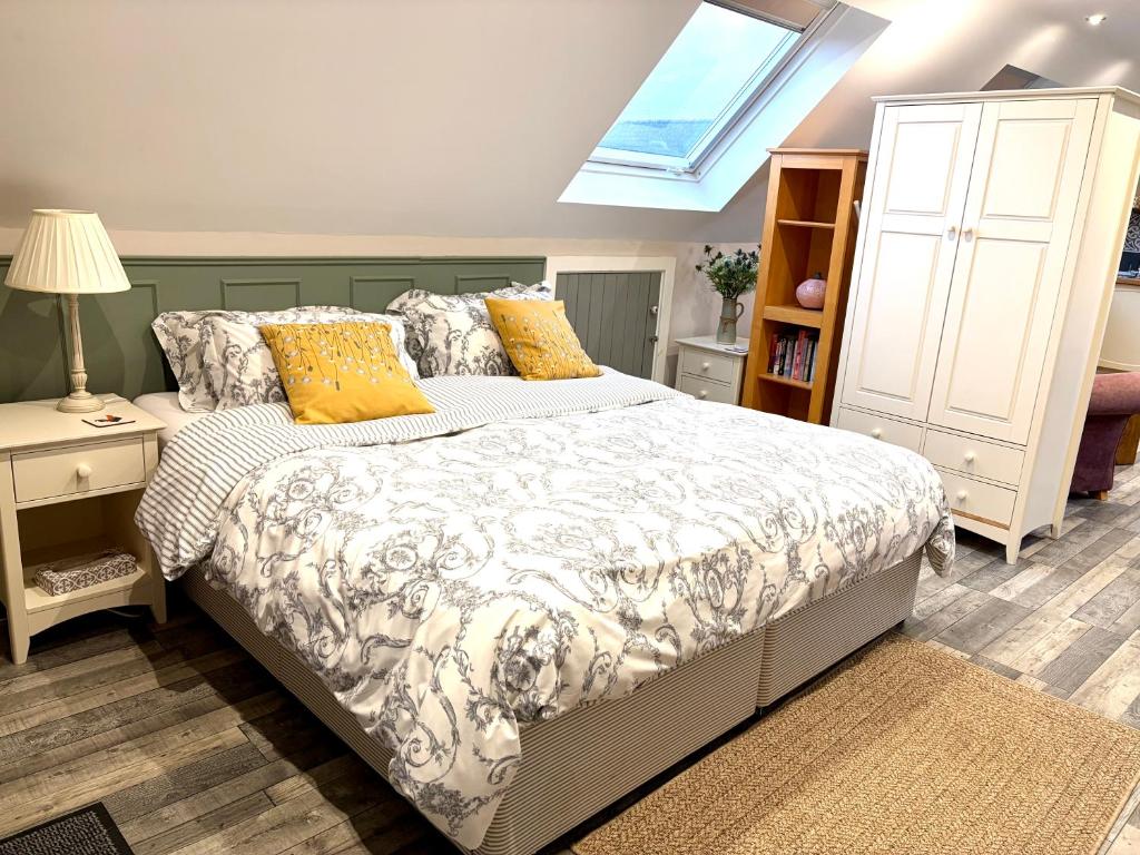 een slaapkamer met een bed met gele kussens en een raam bij The Honeysuckle Coop in Grantham