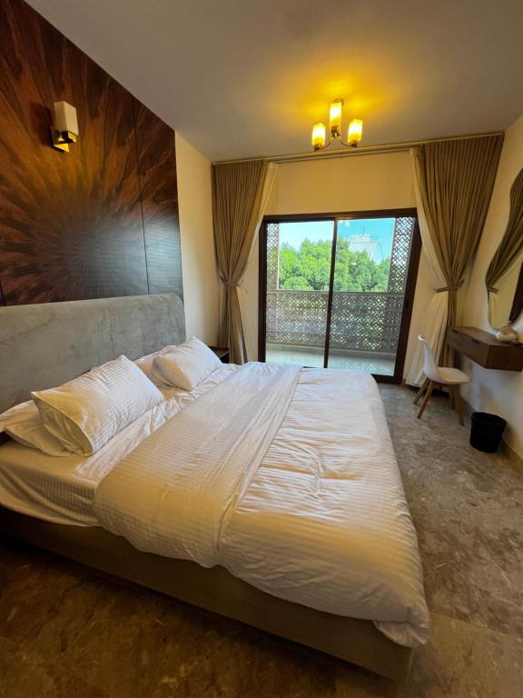 une chambre avec un grand lit blanc avec une fenêtre dans l'établissement Mazaya VIP Stay, à Mawāliḩ