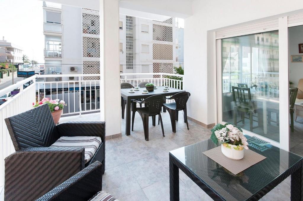 a living room with a table and chairs on a balcony at Oreneta in Puerto de Gandía