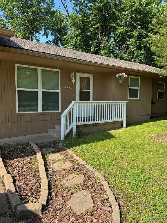 a house with a porch and a white fence at Wolf Creek Escape Grove OK in Grove