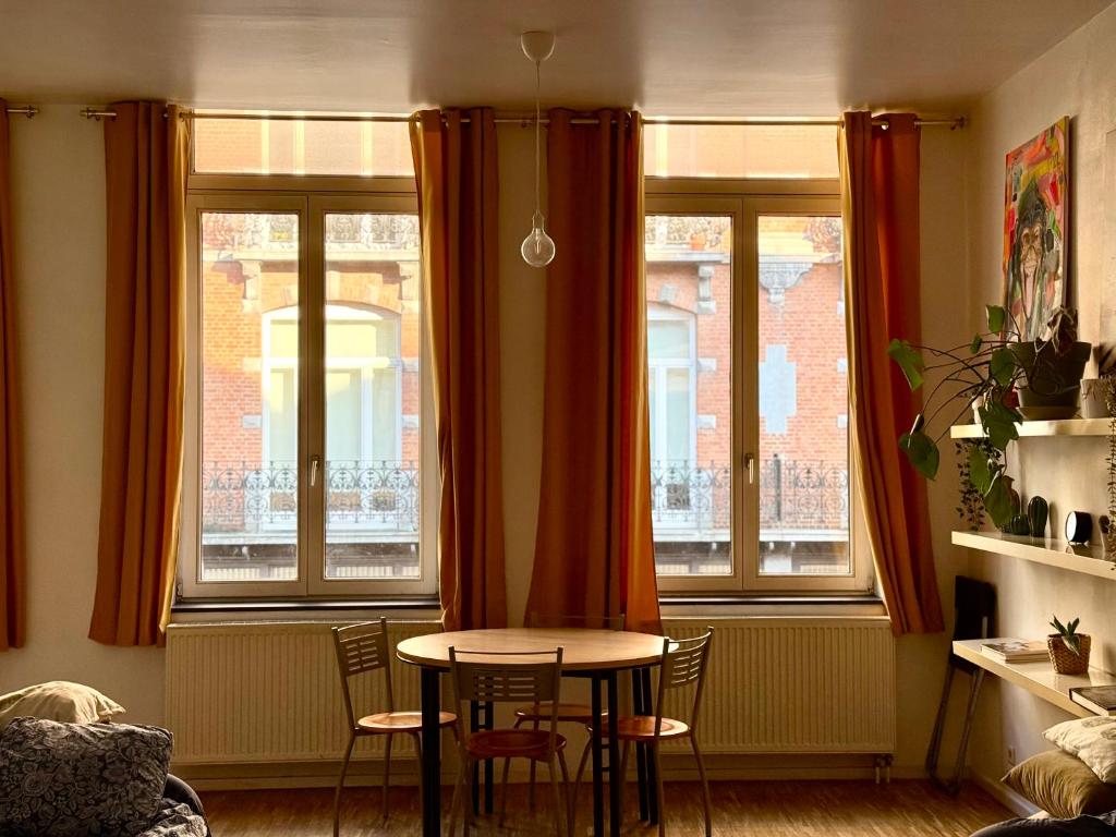 een tafel en stoelen in een kamer met ramen bij Central Hub in Brussel