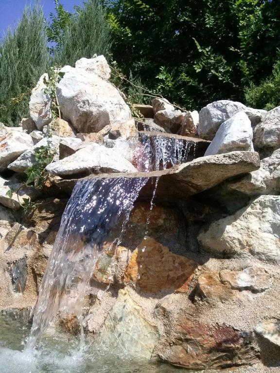 a water feature in a rock wall with a waterfall at Rajski vrt in Vrdnik