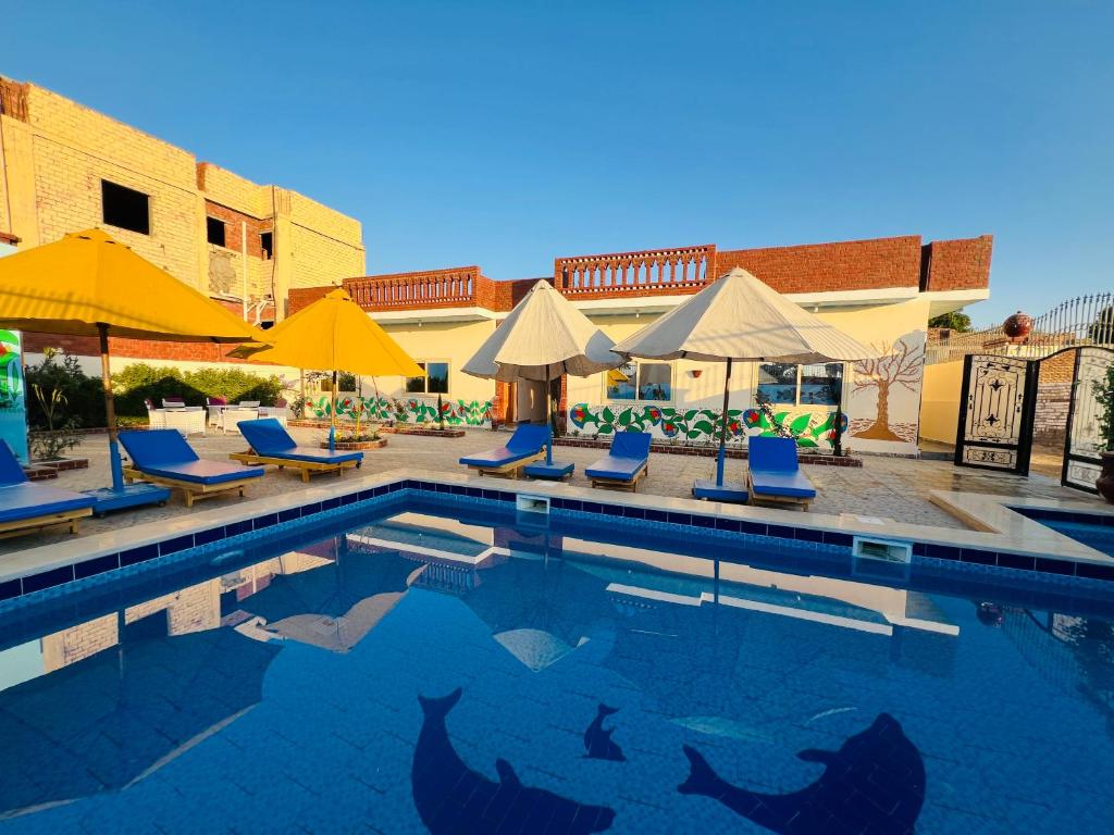 a swimming pool with chairs and umbrellas at Horus Golden Luxor in Luxor